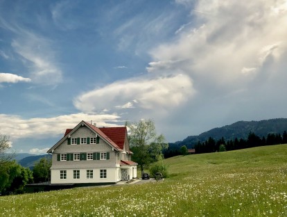 Das ehemalige Schulhaus steht idyllisch auf einer Blumenwiese